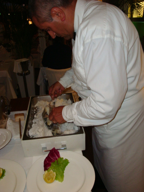 il cameriere pulisce il branzino di Orbetello al sale dolce della salina Camillona di Cervia 