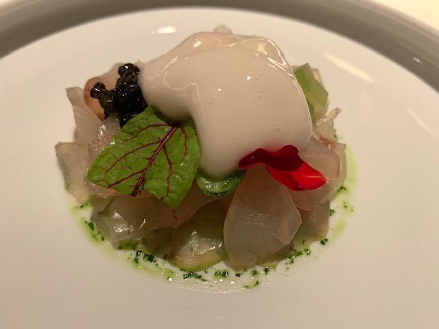 Spigola spigola pescata e marinata a secco con zucchero e spezie, spuma di mare e cetriolo in osmosi