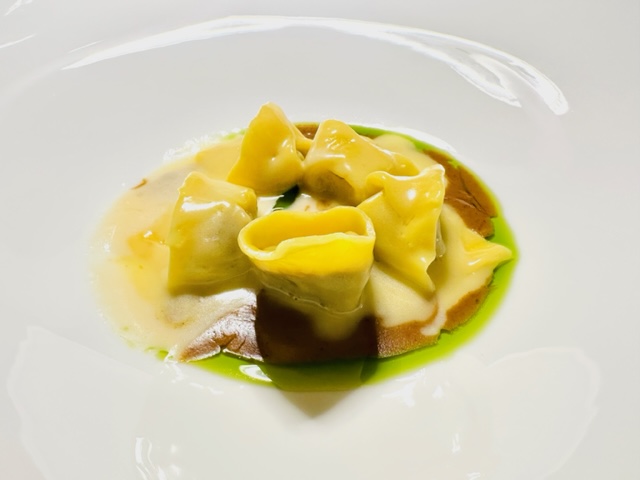 Raviolo di Vicciola piemontese, nocciole, burro bianco ed erbe alpine